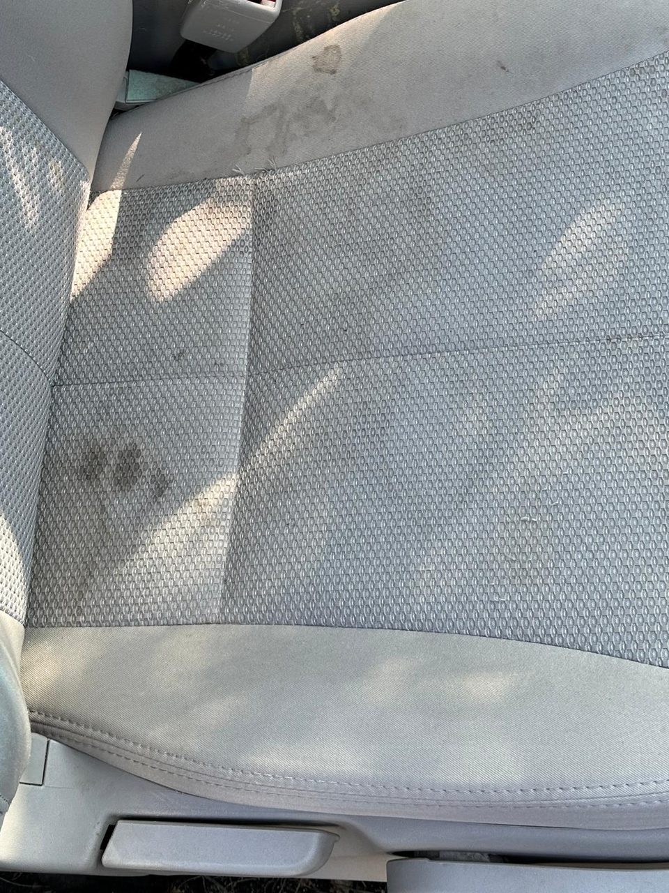 Stained fabric car seat before cleaning — Arc Detailing Calgary